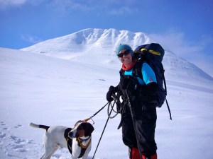 Glad jente og hund med Storsølnkletten i bakgrunnen